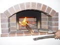 Longer size of fire wood sticks out of dome.