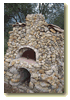 Picture of wood pizza oven with nice rock walls.