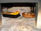 Roasting a whole chicken and vegetables in a wood fired oven.