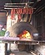 Picture describes how to smoke sausages in smoke from fire from wood oven.