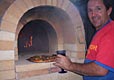 Picture of red building bricks, blue stone masonry on wood oven.